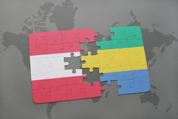 puzzle with the national flag of austria and gabon on a world map background.