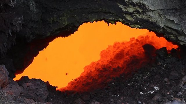 Eruption active Tolbachik Volcano on Kamchatka - viscous red hot lava flows into the hole of the lava flow. Russia, Far East, Kamchatka Peninsula, Klyuchevskaya group of volcanoes.