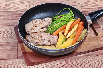 Home made ,Cooking pork steak with mixed vegetables(as sliced potato ,carrot,mushroom,corn and asparagus) in pan  before served.