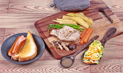 Home made ,Pork steak and mixed vegetables on butcher served served with side dish as parmesan cheese bread ,sausage ,shiitake fresh mushroom soup and salad.