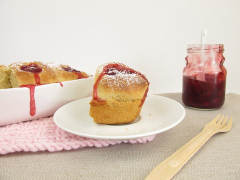 Selbst gebackene Buchteln mit Preiselbeermarmelade und Puderzucker