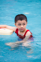 Fototapeta na wymiar Asian Chinese Little Boy Swimming With Floating Board