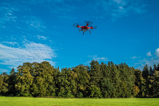 Rote Drohne im Flug unter blauem Himmel