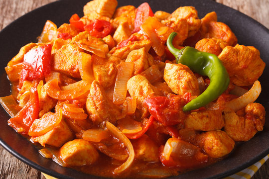 Indian curry Chicken Jalfrezi with spices, tomato sauce and capsicums macro. horizontal
