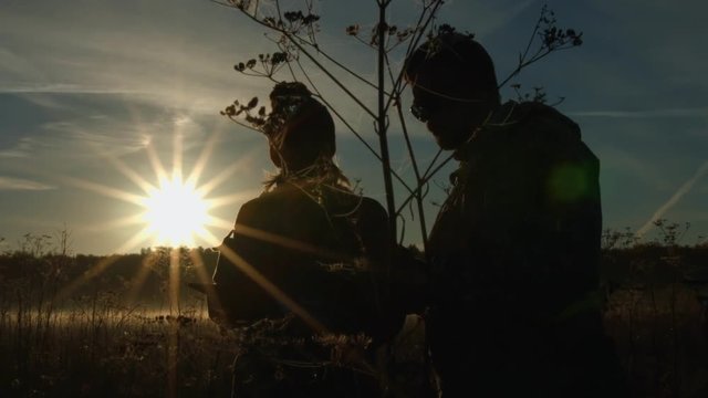 Silhouettes of men and women against the background of the sun. Slow motion.

Man and woman showed hand into the distance on the background of the rising sun.