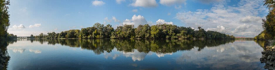 Early autumn landscape panorama with the river Vah and a train crossing the railway bridge at one side and road bridge at other side.