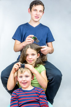 Three children who comb each others head. Efficient head lice treatment, studio portrait shot. 