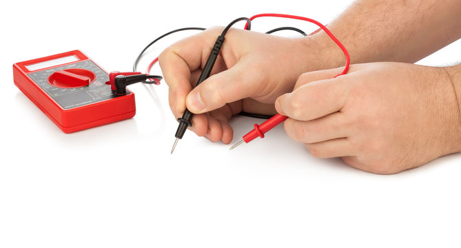 Hands and electric multimeter