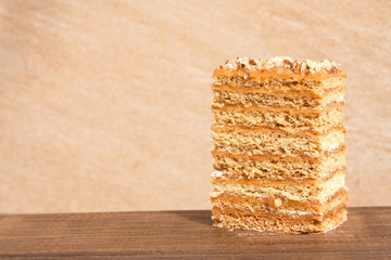 A piece of cake outdoors. Beige background. Close-up. Selective focus.