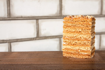 A piece of cake outdoors. White brick background. Close-up. Selective focus.