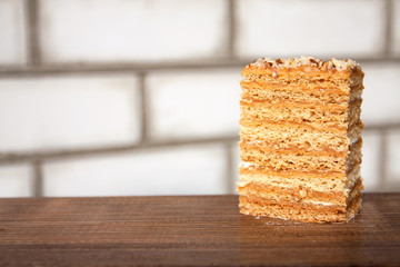 A piece of cake outdoors. White brick background. Close-up. Selective focus.