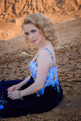 Portrait of beautiful girl in blue dress on sand beach nature