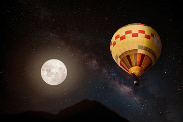 Naklejka premium Beautiful fantasy of hot air balloon and full moon with milky way star in night skies background. Retro style artwork with vintage color tone