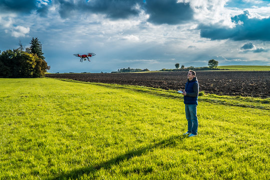 Drohne in der Luft bei Mann auf grüner Wiese