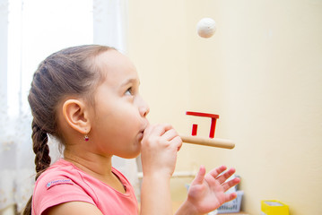 Little girl in class with a speech therapist . The use of special tools for speech correction.