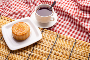 Chinese mid autumn festival foods. Traditional moon cakes on table setting with teacup.
