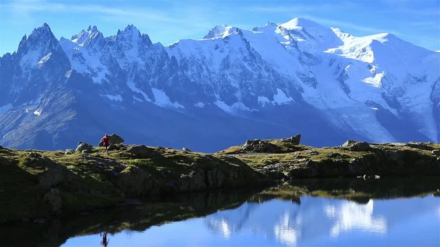 Athlete trail running at a lake (Lac De Cheserys) with the famous Mont Blanc in the background.