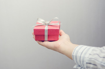 Closeup, Woman hand holding red gift box, female giving gift, New year holidays and greeting season concept