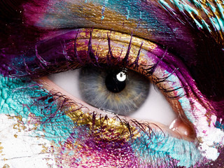 Beauty, cosmetics and makeup. Magic eyes look with bright creative make-up. Macro shot of beautiful woman's face with perfect art make up. Closeup of female eye. Body art