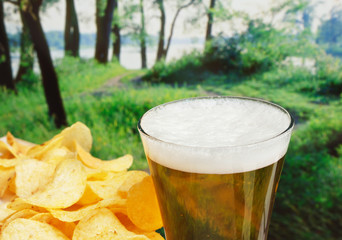 glass of beer and potato chips in a landscape