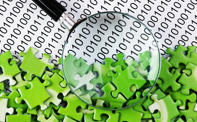 puzzles and magnifying glass on a binary code