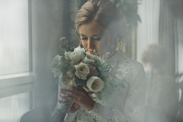 Blurred picture of a stunning bride smelling a wedding bouquet