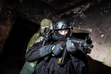 Special forces/anti-terrorist unit or contractor team during night CQB mission/operation (color toned image, very harsh lighting is used on this shot to underline the atmosphere of night mission)