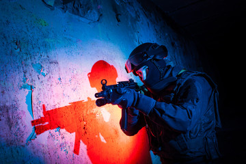 Special forces/ anti-terrorist police unit/private military contractor during night CQB hostage rescue raid/operation/mission (red and blue light for underline the atmosphere) - obrazy, fototapety, plakaty