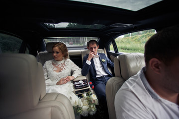 Thoughtful wedding couple sits on the back sit uder a panoramic