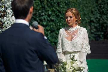 Pretty bride tries to keep her tears listening to the groom's oa