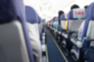 Abstract blurred aircraft cabin view of economy class with passe