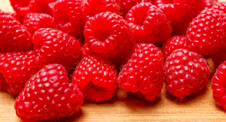 Raspberry berries on a wooden surface background