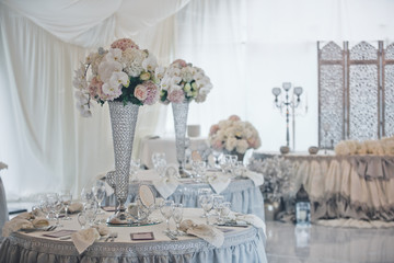 The vases with flowers on the wedding tables