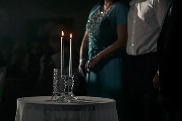 The brides stand near table with cendals
