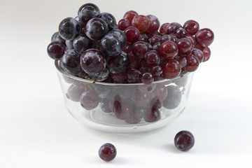 red grape and black grape in bowl on white table
