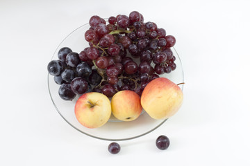 apple and grape on plate glass