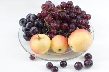 apple and grape on dish glass