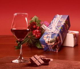 Red wine glass with chocolate and Christmas presents