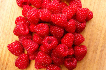 Raspberry berries on a wooden surface background