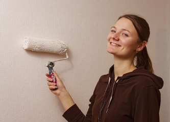 young woman painting her home wall. Handmade