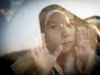 Little boy looking through window