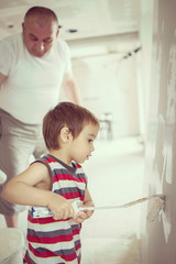 Little cute boy painting on a wall