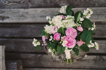 Beautiful bouquet of jasmine and pink garden roses with lace ribbons on old wooden pier