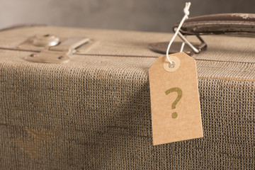 Name tag  with questionmark on old vintage suitcase. Concept of lost luggage, tourism and holiday destination. - 123634953