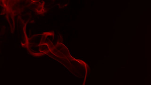 Motion of red smoke on black background.