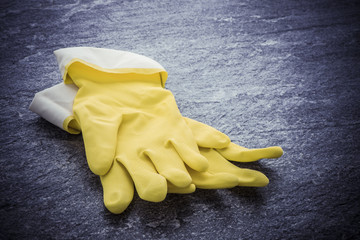 Yellow rubber gloves lying on stone surface. Image showing concept of cleaning, household work and protective wear. - 123635729