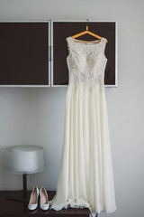 white wedding dress and leather shoes during bride's preparation in the morning