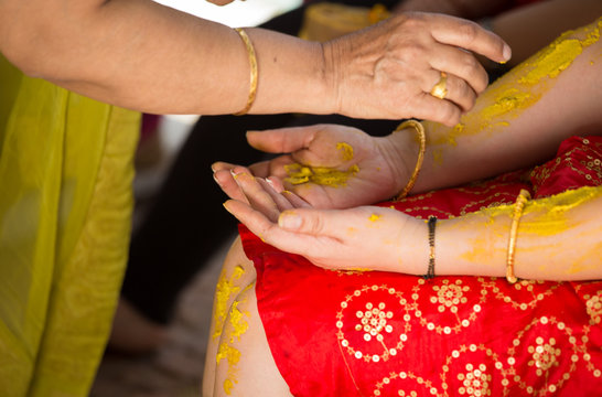 haldi ceremony - a tradition at indian weddings where the bride and groom are rubbed with turmeric paste  by all relatives,family members and friends for glowing and beautiful skin