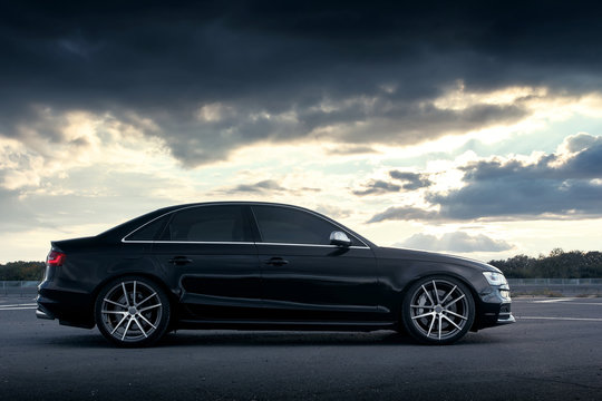 Fototapeta Black car at parked on countryside road at sunset