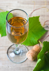 glass of wine and vine on  wooden table